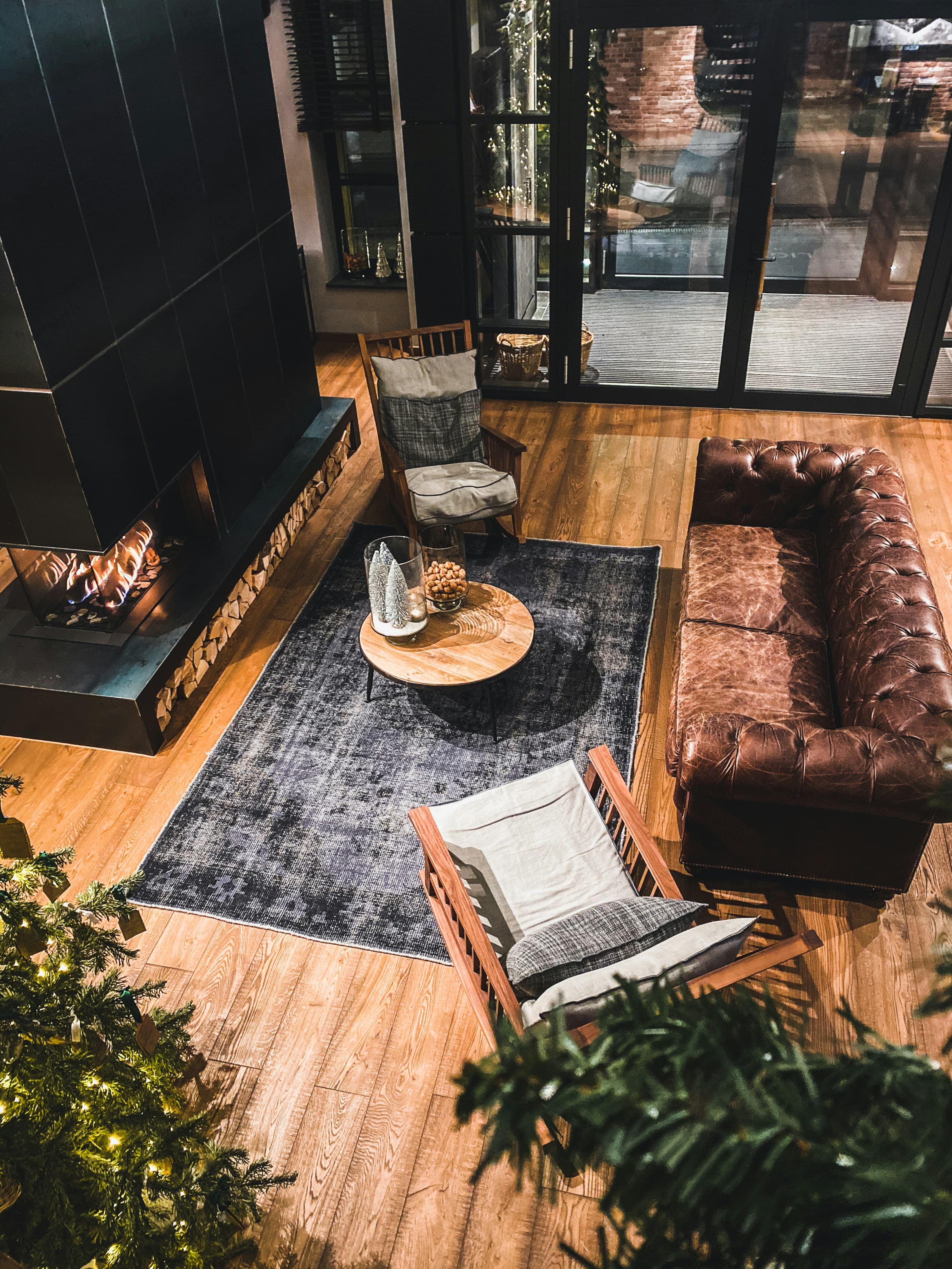 Cozy living room with area rug, leather sofa, and clean hardwood floors